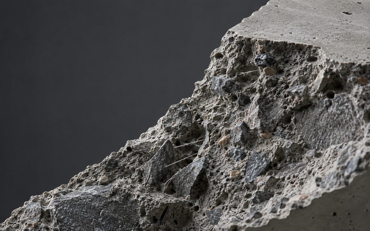 Fractured concrete revealing aggregate and reinforcing fibers