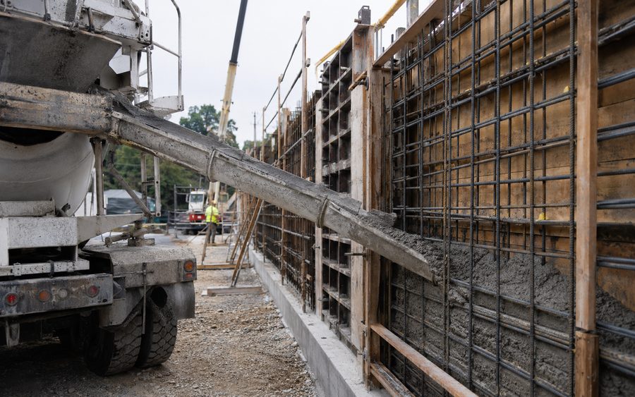 Concrete being placed into a reinforced wall form on site