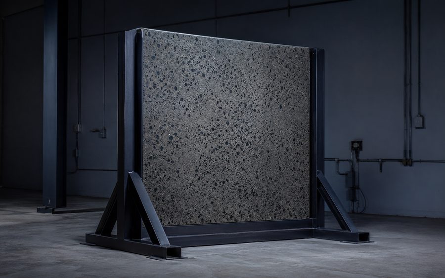 A carbon-flecked CarbonCrete panel mounted in a steel test frame