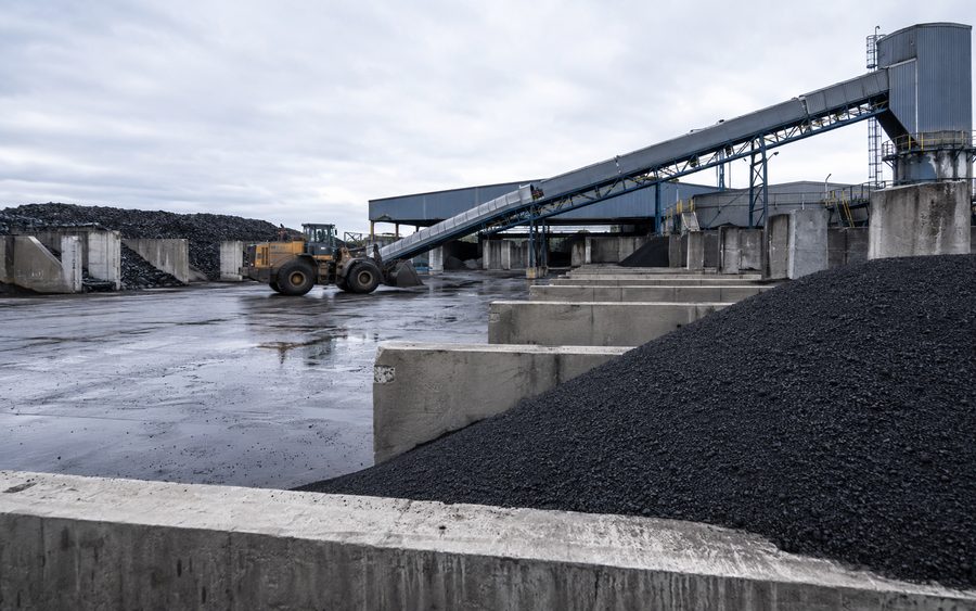 Reclaimed carbon processing yard with bulk material bays and conveyor